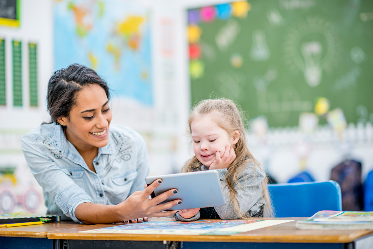 Teacher and child learning on tablet